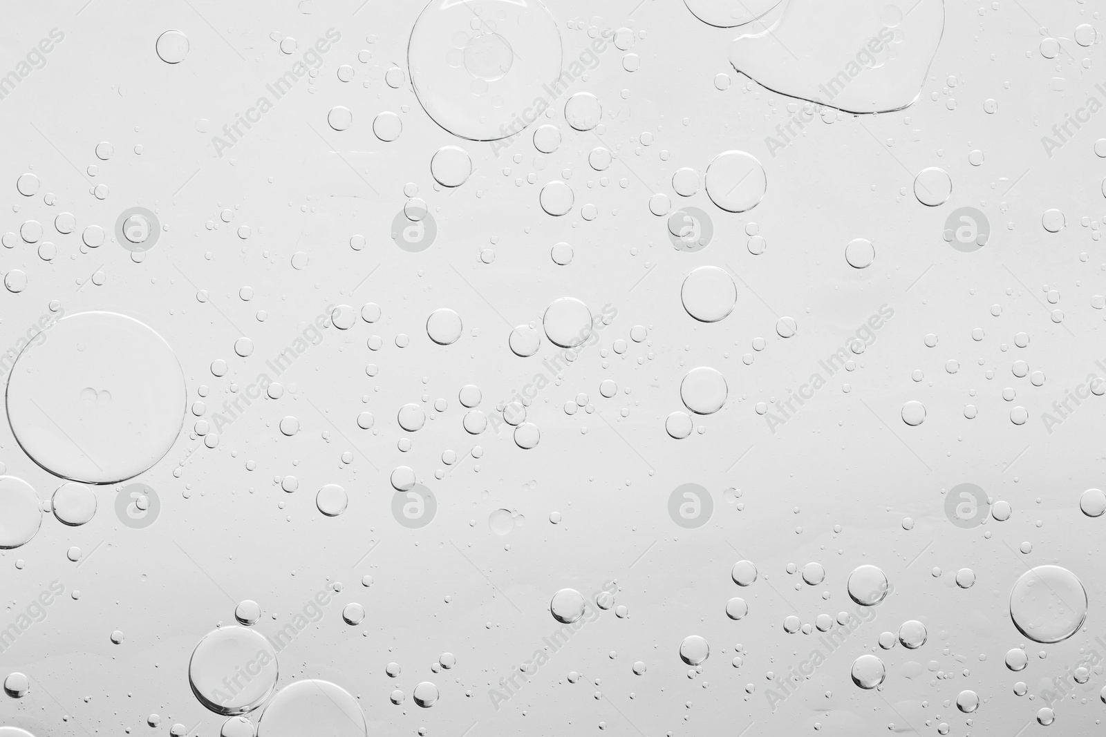 Photo of Sample of cosmetic oil on light grey background, macro view