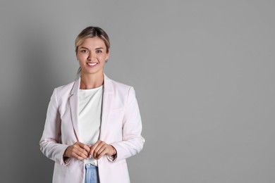 Beautiful woman in stylish jacket on grey background