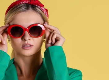 Photo of Beautiful woman in stylish green jacket on yellow background