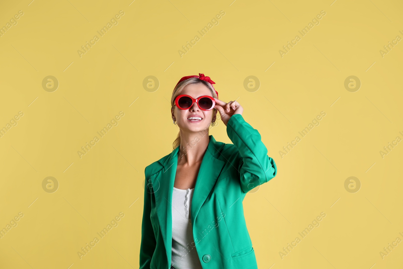 Photo of Beautiful woman in stylish green jacket on yellow background