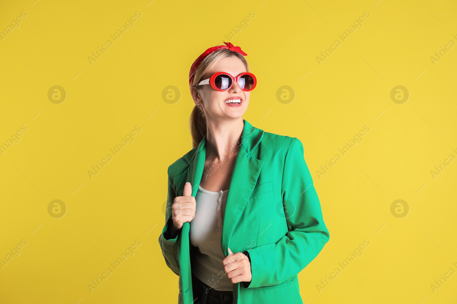 Photo of Beautiful woman in stylish green jacket on yellow background