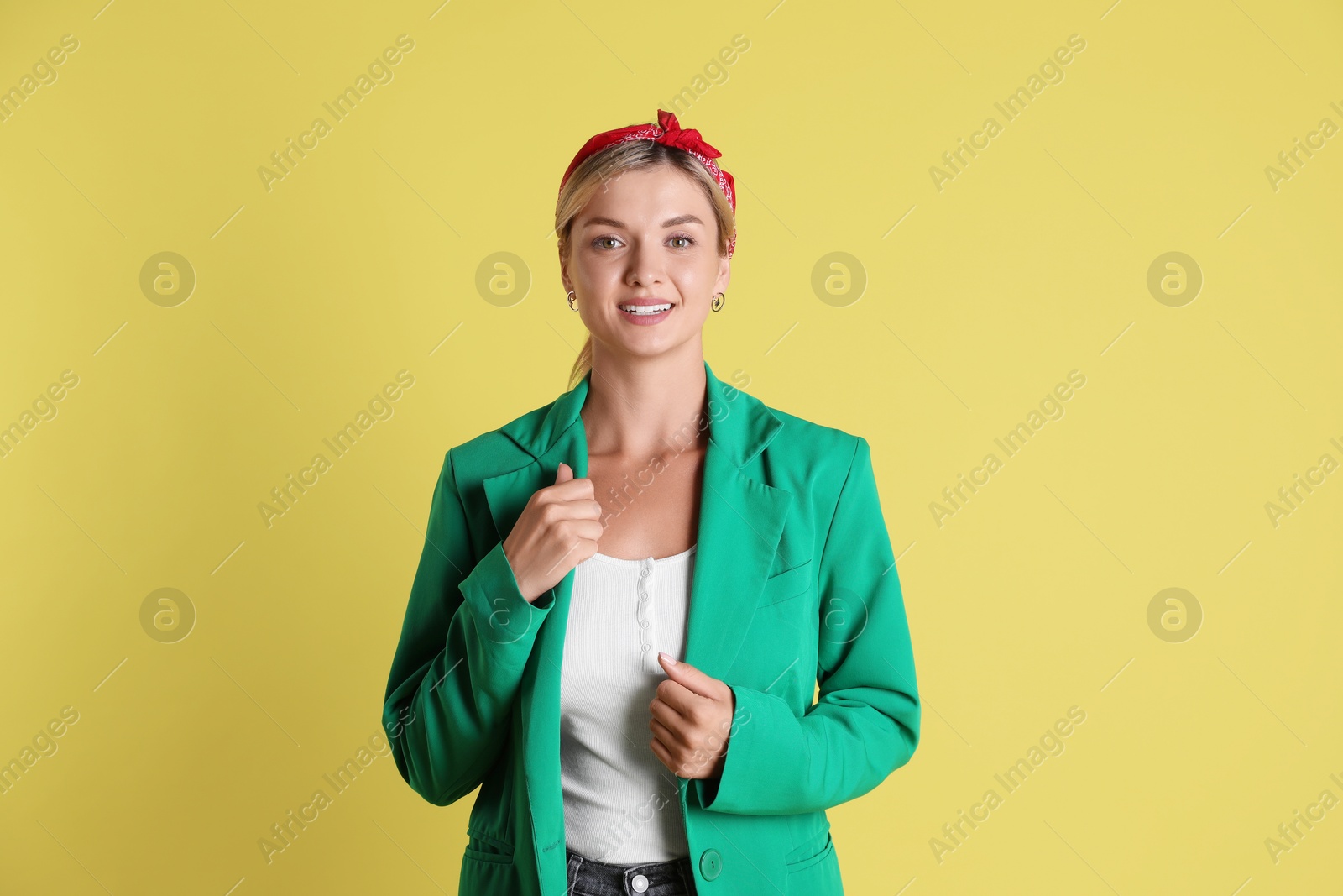 Photo of Beautiful woman in stylish green jacket on yellow background