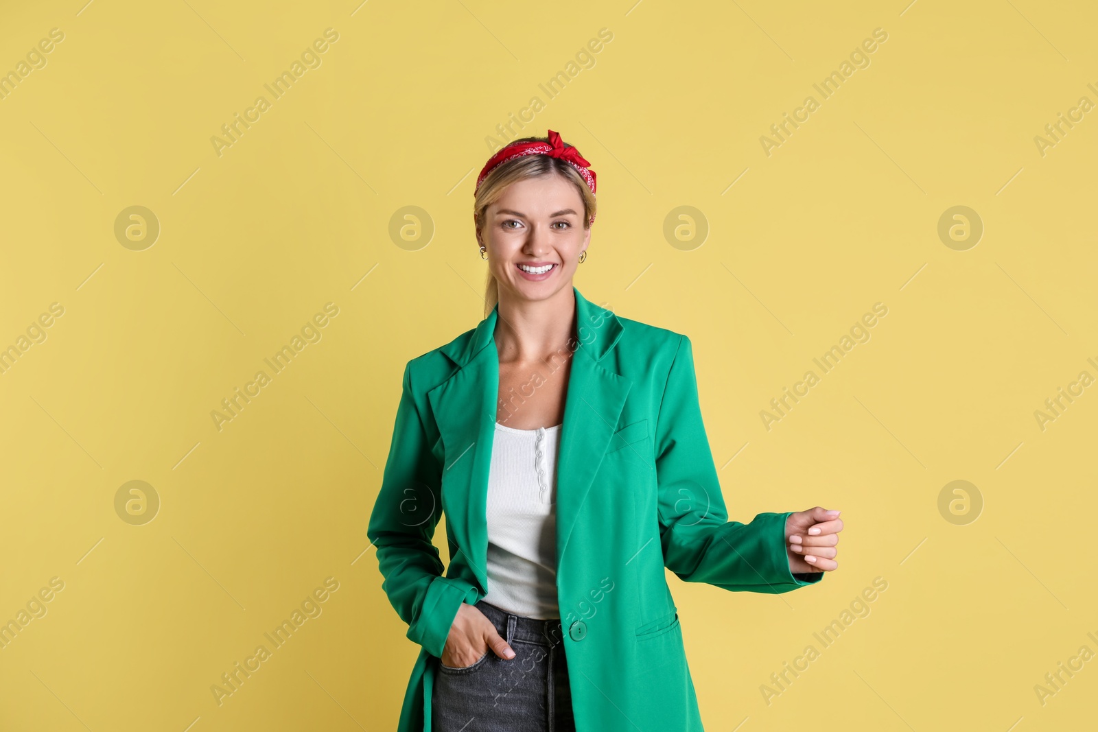 Photo of Beautiful woman in stylish green jacket on yellow background