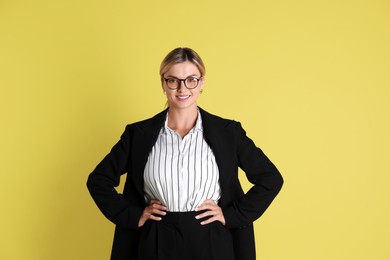 Photo of Beautiful woman in stylish black suit on yellow background