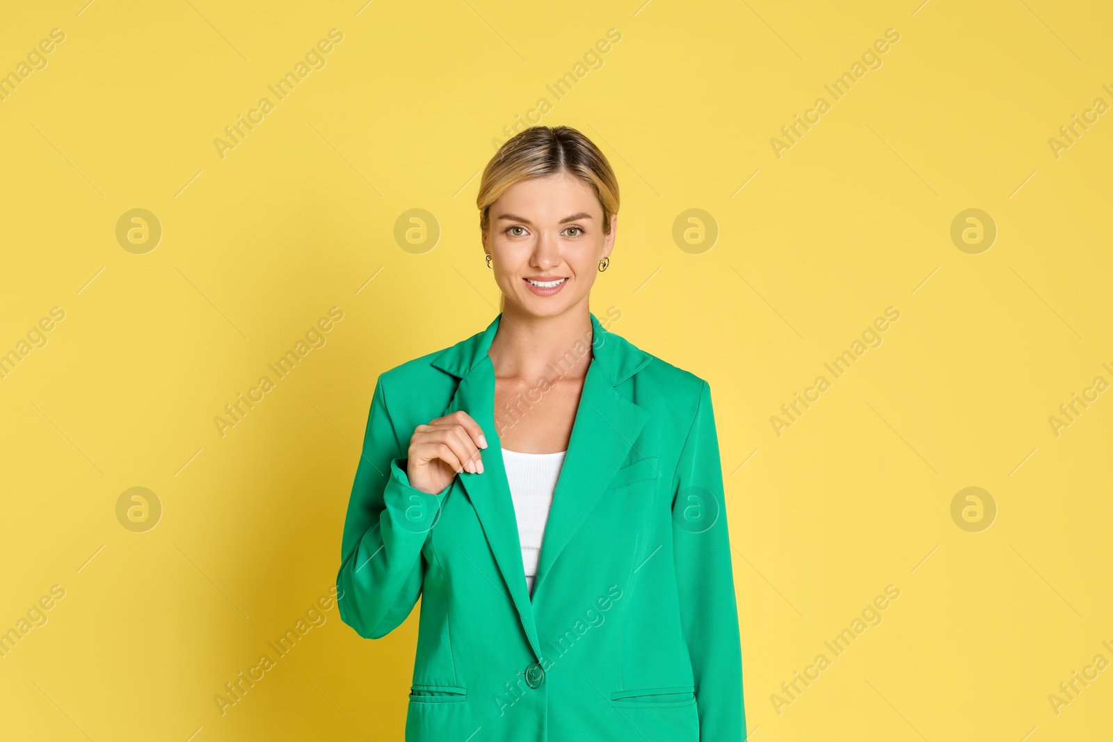 Photo of Beautiful woman in stylish green suit on yellow background