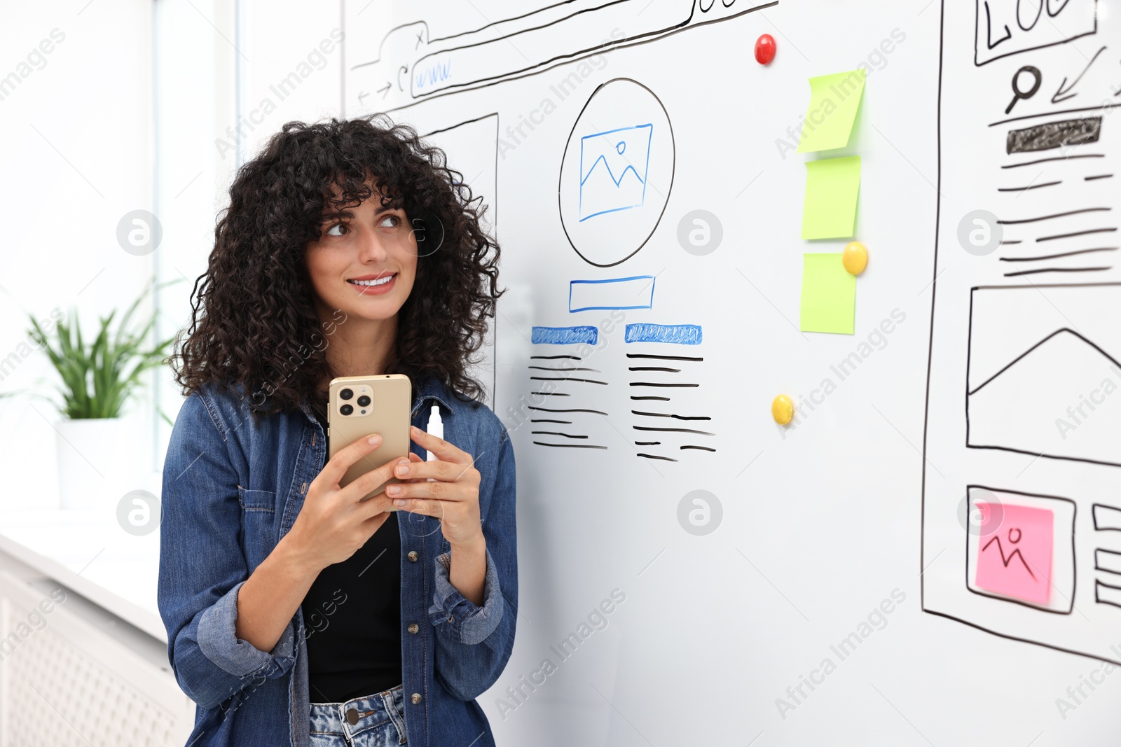 Photo of Developing UI design. Woman planning website wireframe on whiteboard indoors