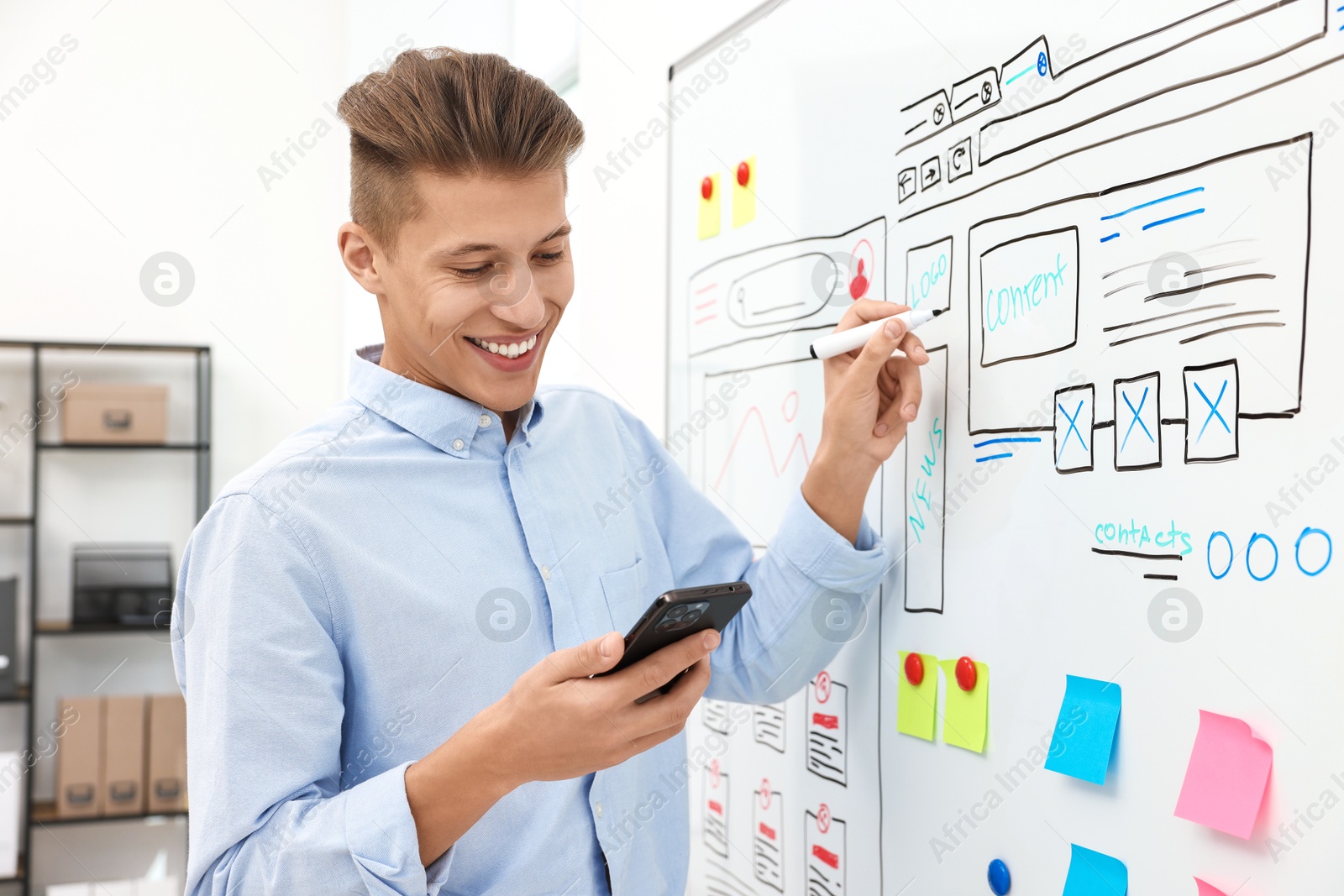 Photo of Developing UI design. Man drawing website wireframe on whiteboard indoors