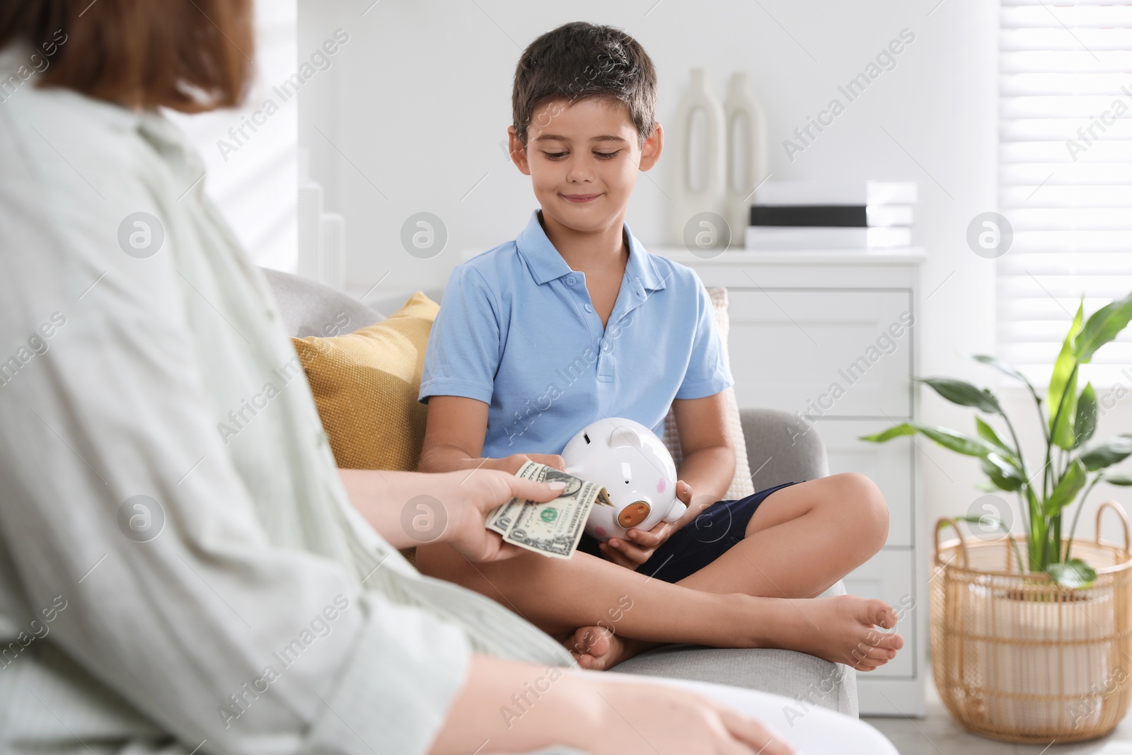 Photo of Mother giving pocket money to her son at home