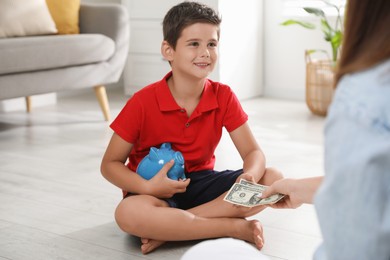 Photo of Mother giving pocket money to her son at home