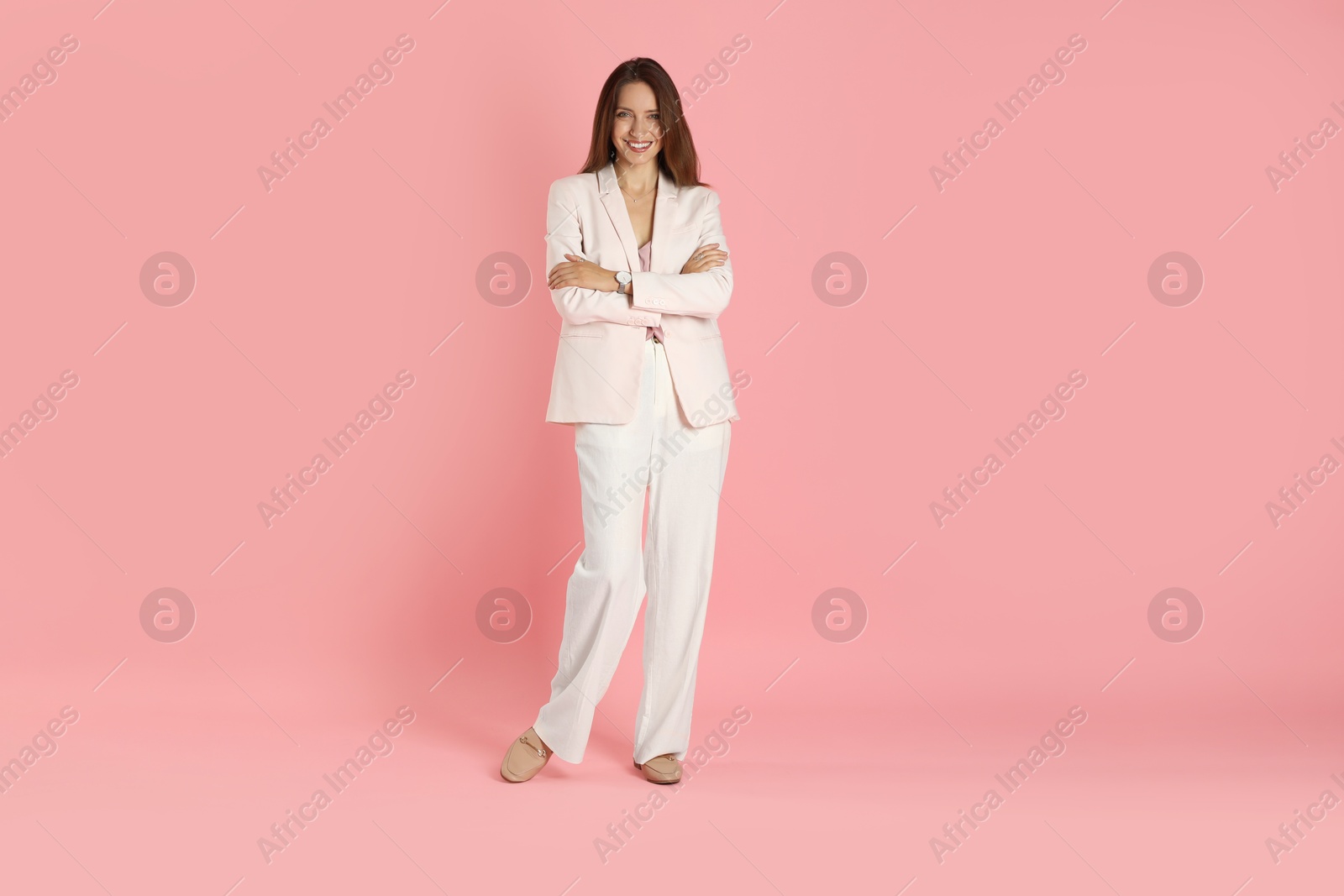 Photo of Beautiful woman in stylish white suit on pink background