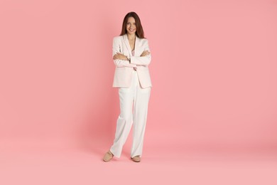 Beautiful woman in stylish white suit on pink background