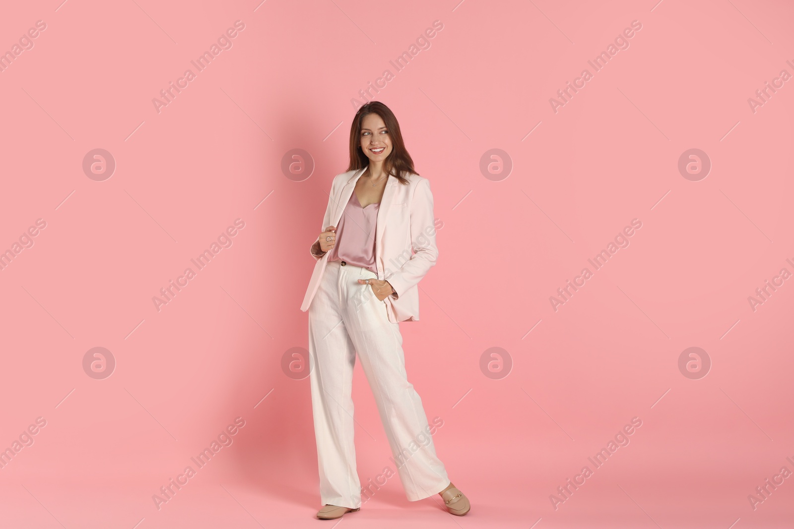 Photo of Beautiful woman in stylish white suit on pink background