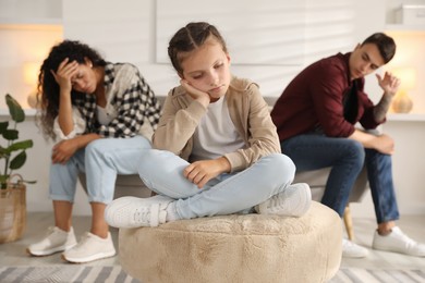 Photo of Divorce concept. Sad couple and their daughter at home