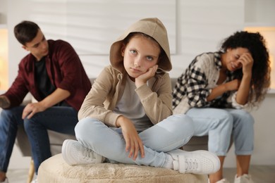 Photo of Divorce concept. Sad couple and their daughter at home