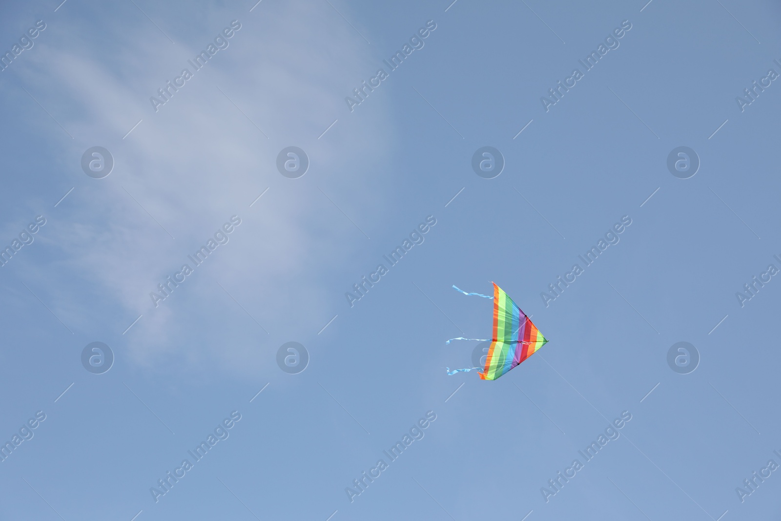 Photo of One colorful kite flying in blue sky. Space for text