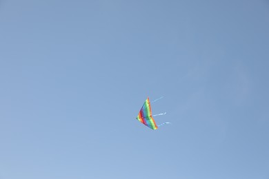 Photo of One colorful kite flying in blue sky. Space for text