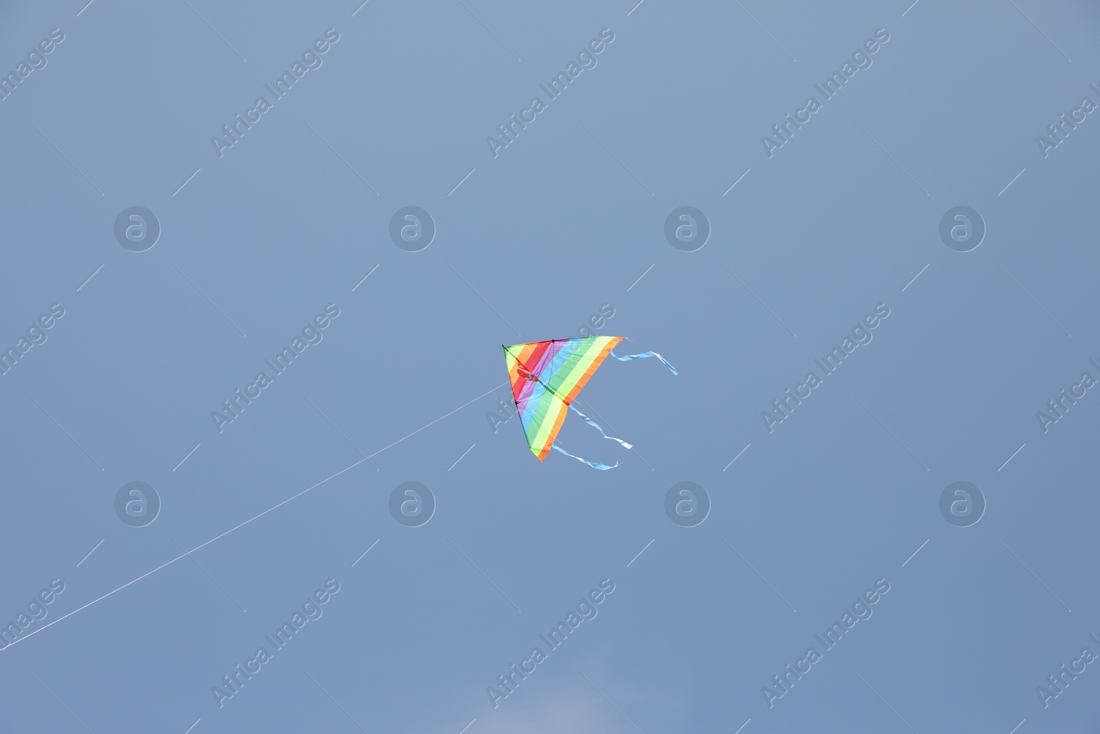 Photo of One colorful kite flying in blue sky