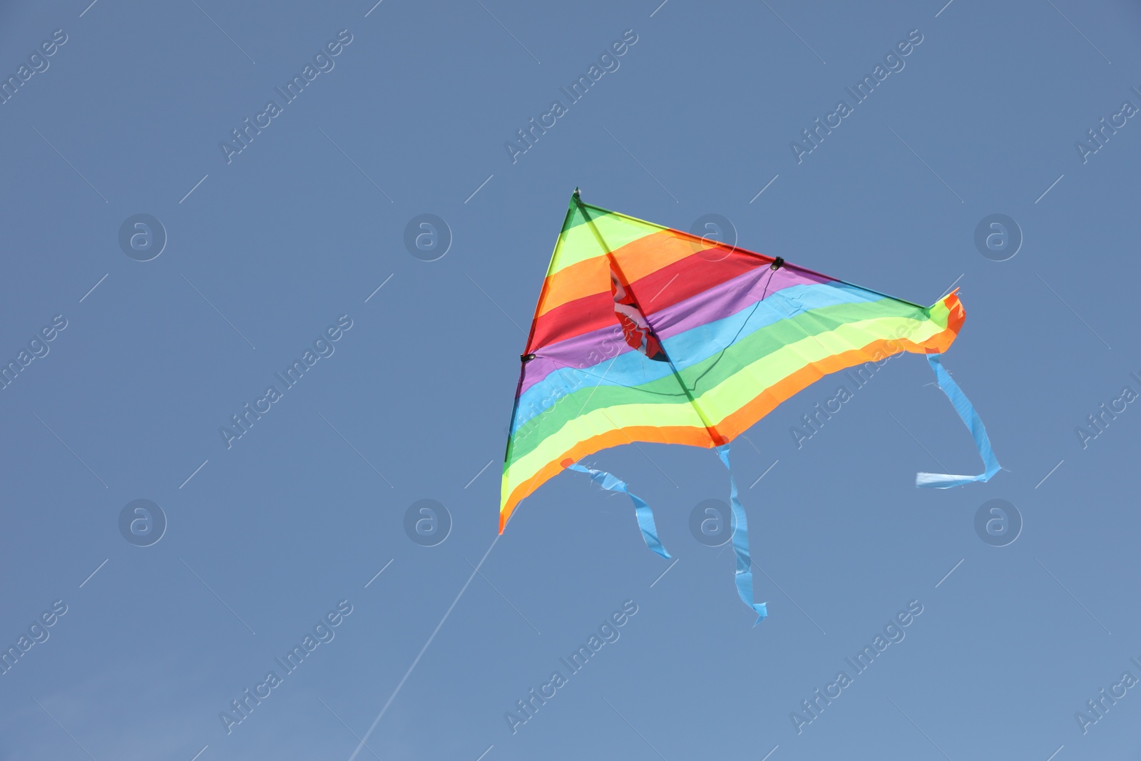 Photo of One colorful kite flying in blue sky