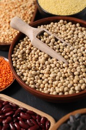 Photo of Different types of legumes and cereals on grey table, closeup