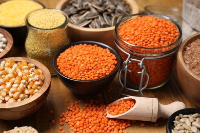 Photo of Different types of cereals, seeds and legumes on wooden table, closeup