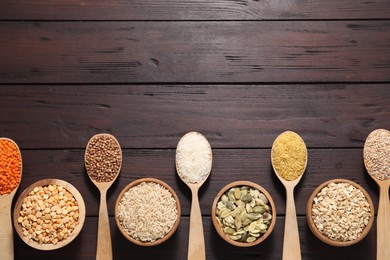 Photo of Different types of cereals, seeds and legumes on wooden table, flat lay. Space for text