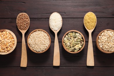 Photo of Different types of cereals and seeds on wooden table, flat lay