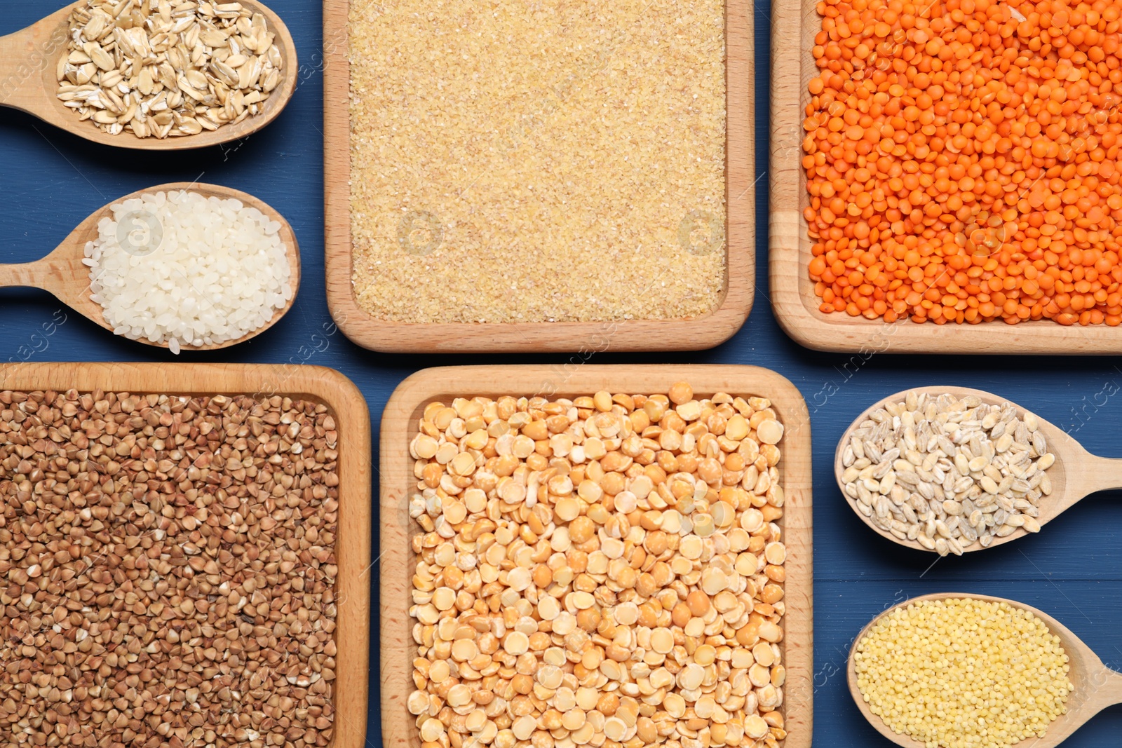 Photo of Different types of legumes and cereals on blue wooden table, flat lay