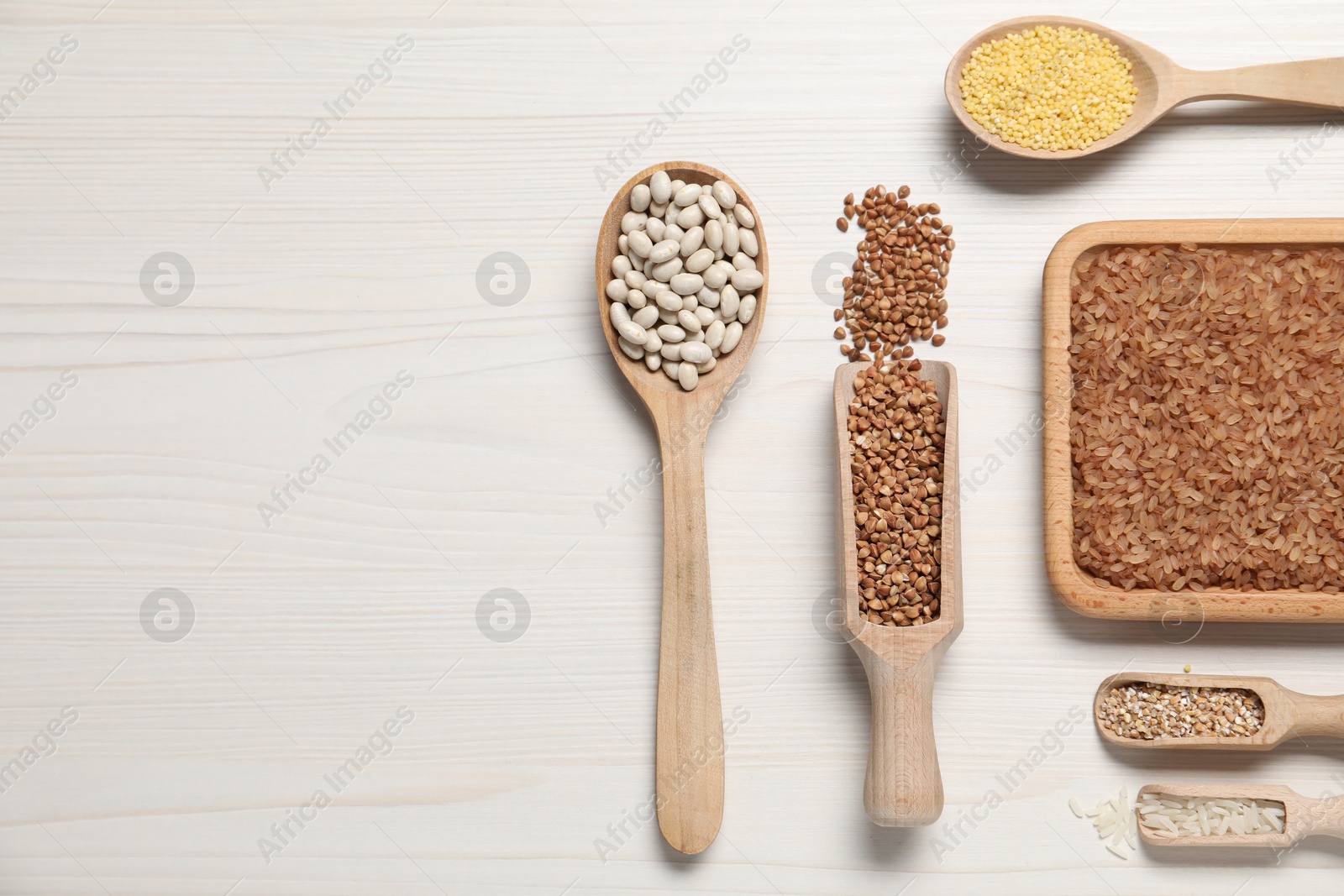 Photo of Different types of legumes and cereals on white wooden table, flat lay. Space for text