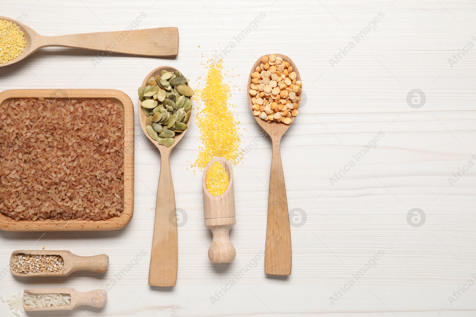 Photo of Different types of seeds and cereals on white wooden table, flat lay. Space for text