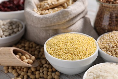 Photo of Different types of legumes and cereals on white table, closeup