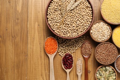 Photo of Different types of legumes, seeds and cereals on wooden table, flat lay. Space for text