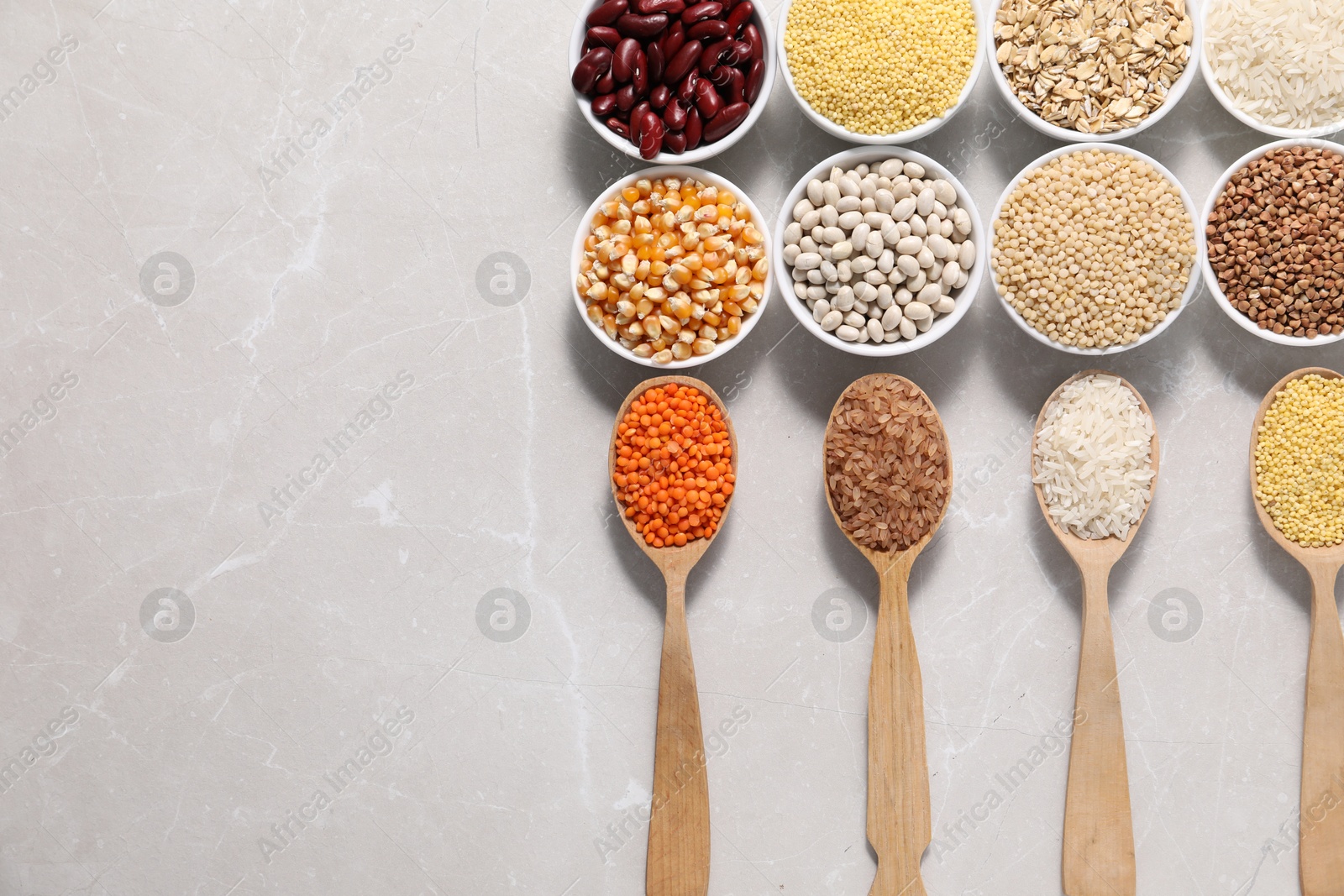 Photo of Different types of legumes and cereals on light marble table, flat lay. Space for text