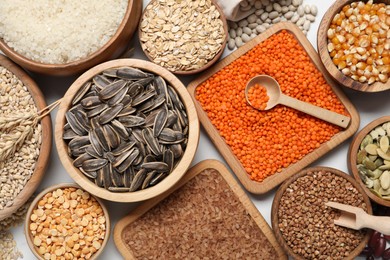 Photo of Different types of legumes, seeds and cereals on white marble table, flat lay