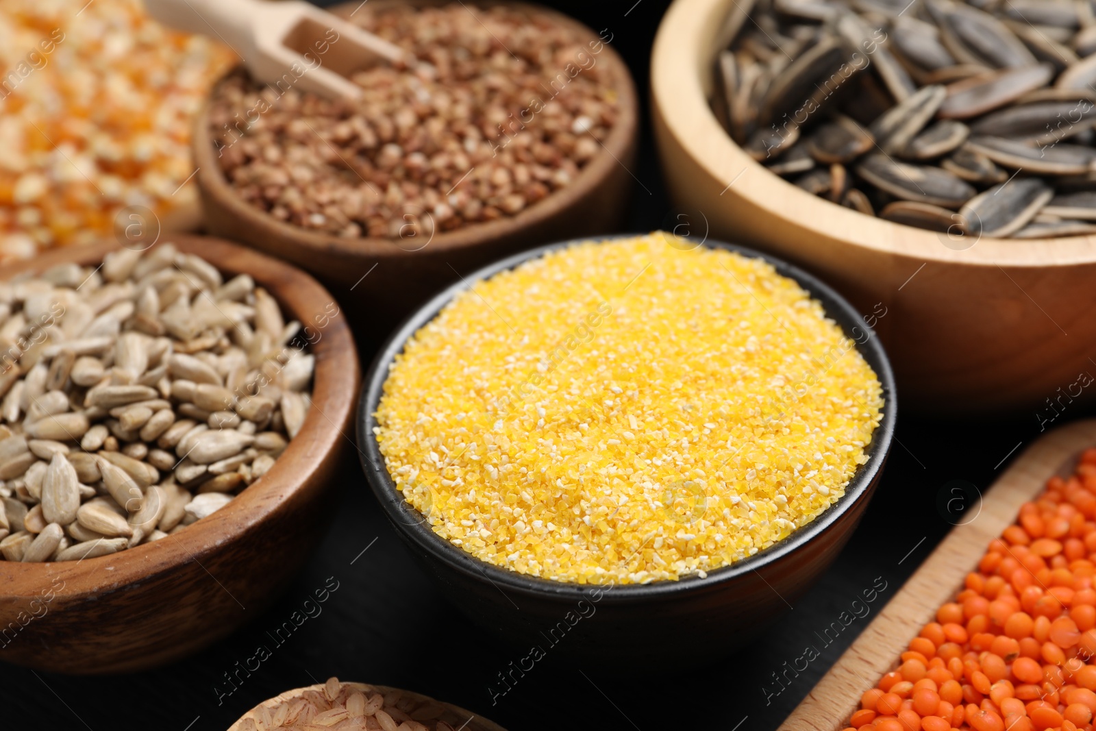 Photo of Different types of seeds and cereals in bowls table, closeup