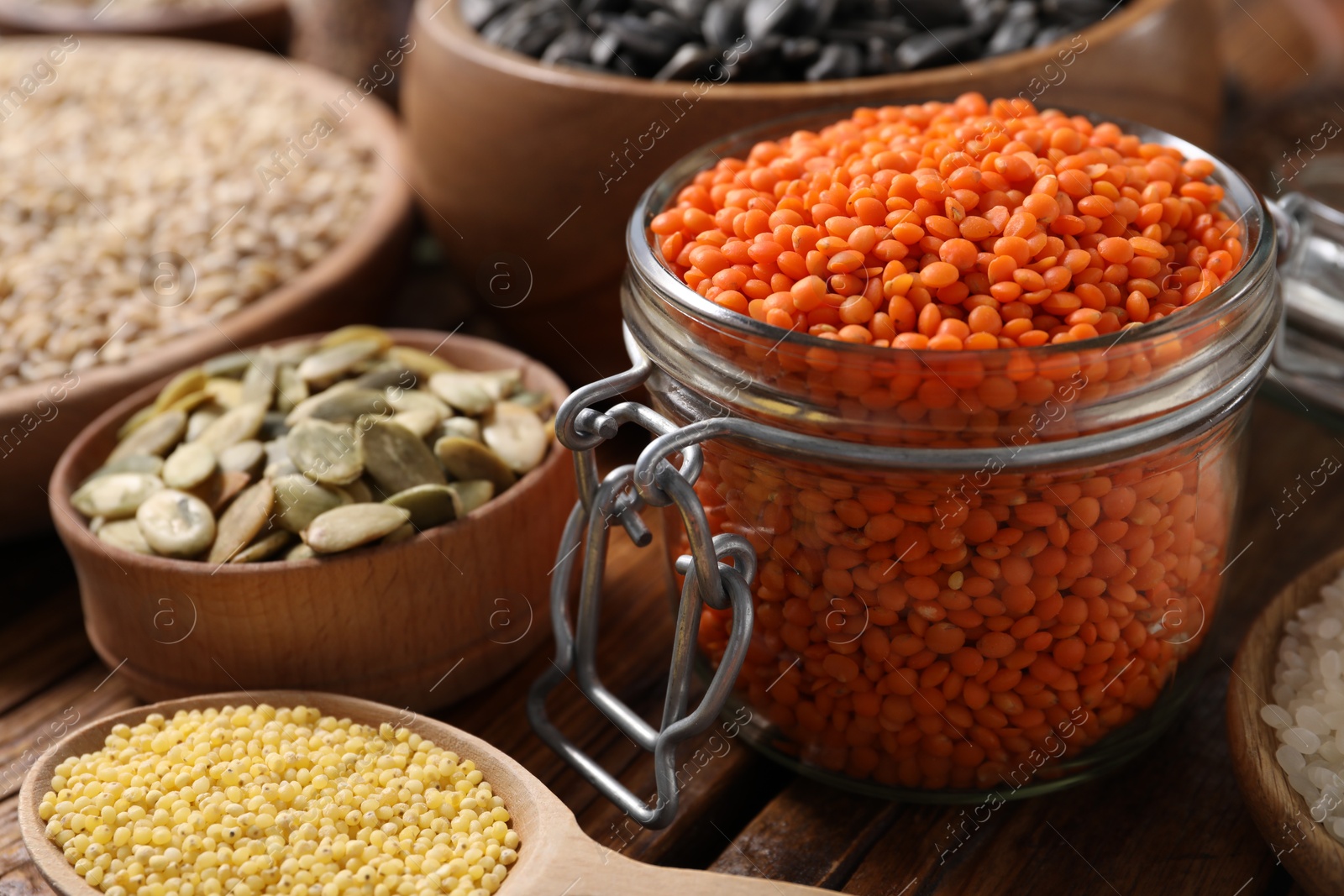 Photo of Different types of cereals, seeds and legumes on wooden table, closeup