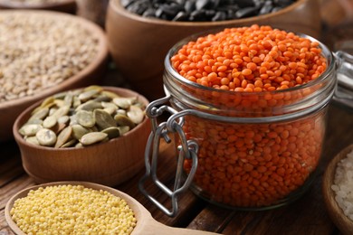 Photo of Different types of cereals, seeds and legumes on wooden table, closeup