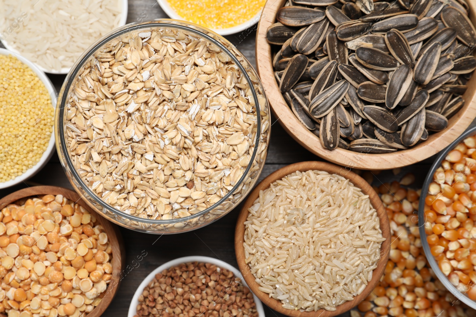 Photo of Different types of cereals and seeds on wooden table, flat lay