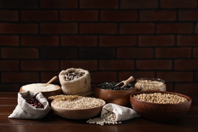 Photo of Different types of cereals, seeds and legumes on wooden table