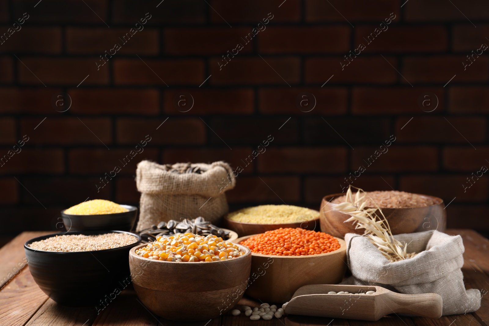 Photo of Different types of legumes, seeds and cereals on wooden table