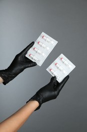 Photo of Professional cosmetologist holding disposable cartridge systems for permanent makeup on grey background, closeup