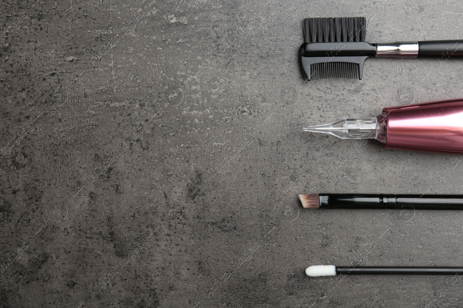 Photo of Professional permanent makeup machine and different brushes on grey background, flat lay. Space for text