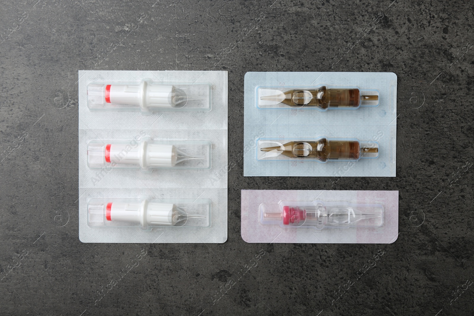 Photo of Many disposable cartridge systems for permanent makeup on grey background, top view