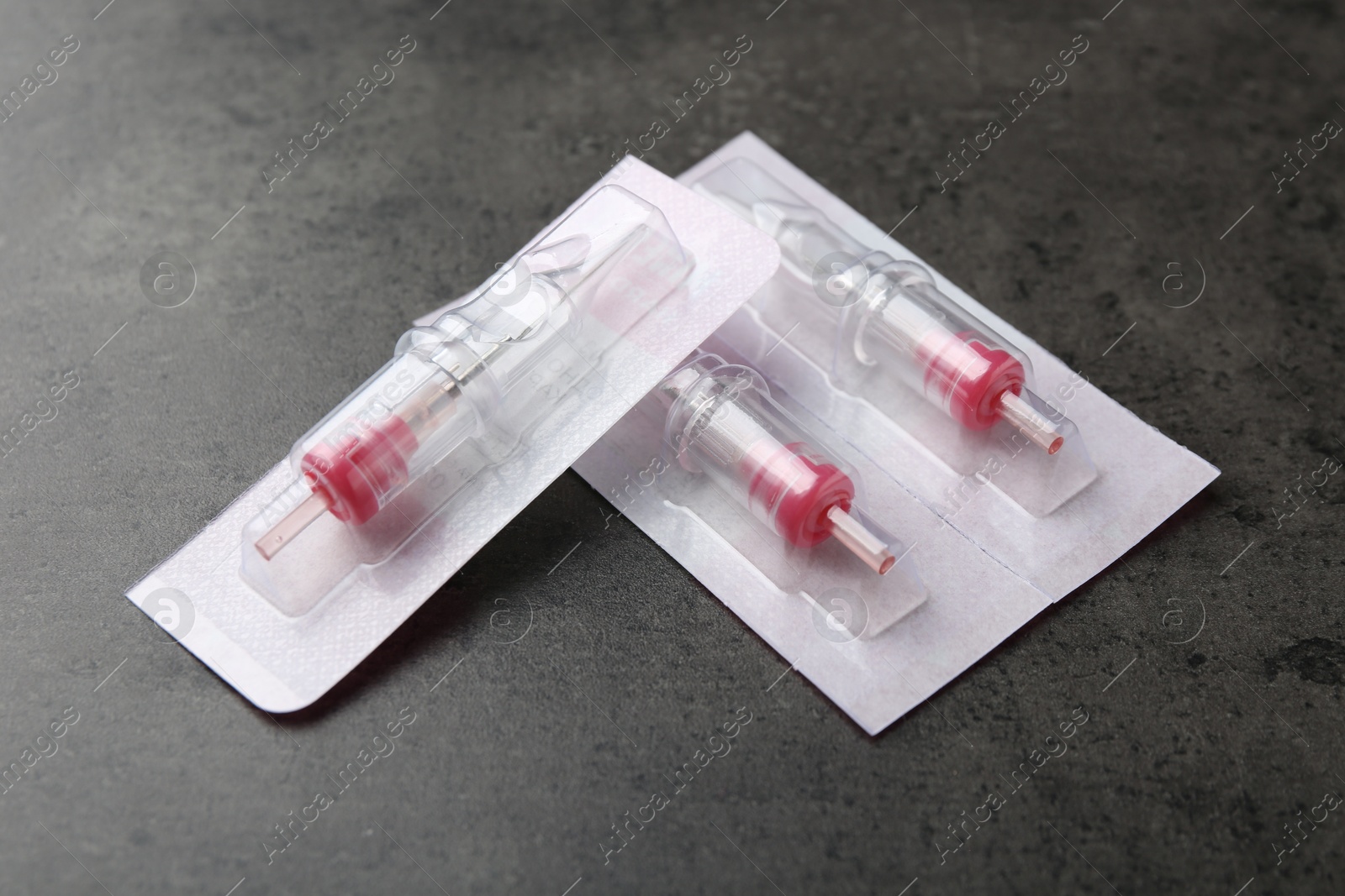 Photo of Many disposable cartridge systems for permanent makeup on grey background