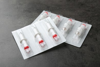 Photo of Many disposable cartridge systems for permanent makeup on grey background