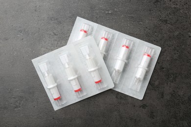 Many disposable cartridge systems for permanent makeup on grey background, top view