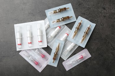 Photo of Many disposable cartridge systems for permanent makeup on grey background, top view