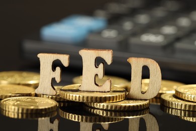 Photo of Letters Fed (Federal Reserve System) and coins on mirror table, closeup