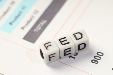 Photo of Cubes with letters Fed (Federal Reserve System) on table, closeup