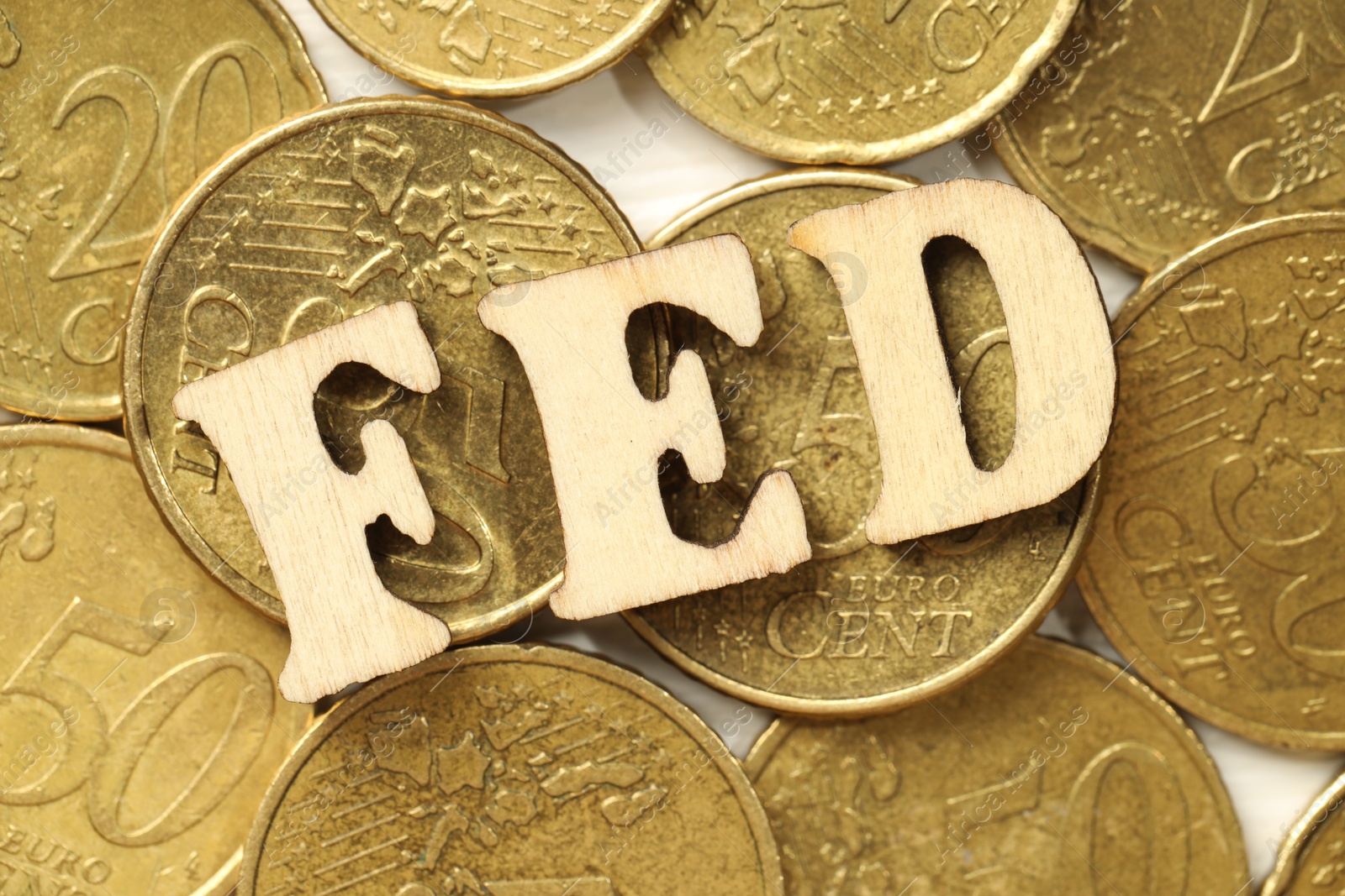 Photo of Wooden letters Fed (Federal Reserve System) and coins on white table, flat lay