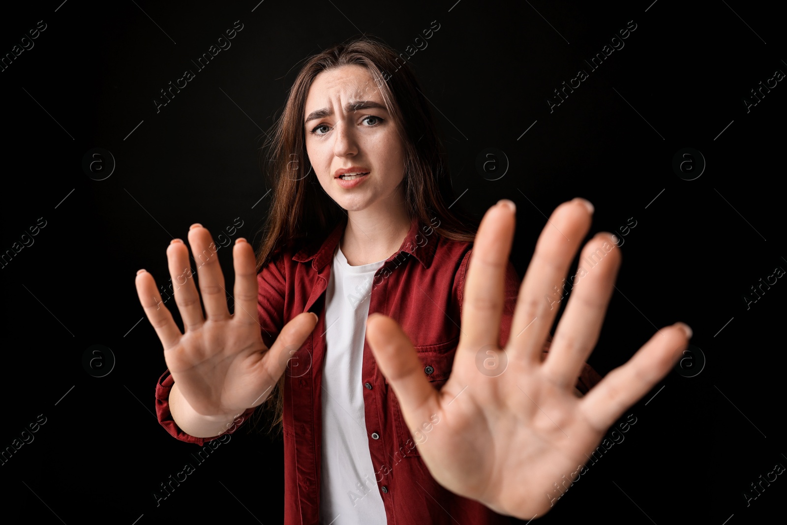 Photo of Portrait of scared woman on black background